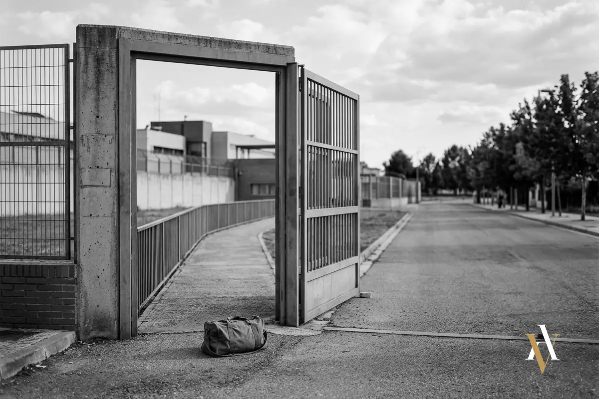 Puerta principal de un centro penitenciario un viernes por la tarde, con una bolsa de viaje junto a la salida